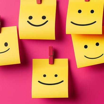 A group of yellow post-it notes with smiley faces on them